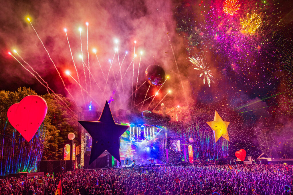 Fireworks, inflatable stars and hearts hover over the Electric Forest Crowd at a String Cheese Incident Set 